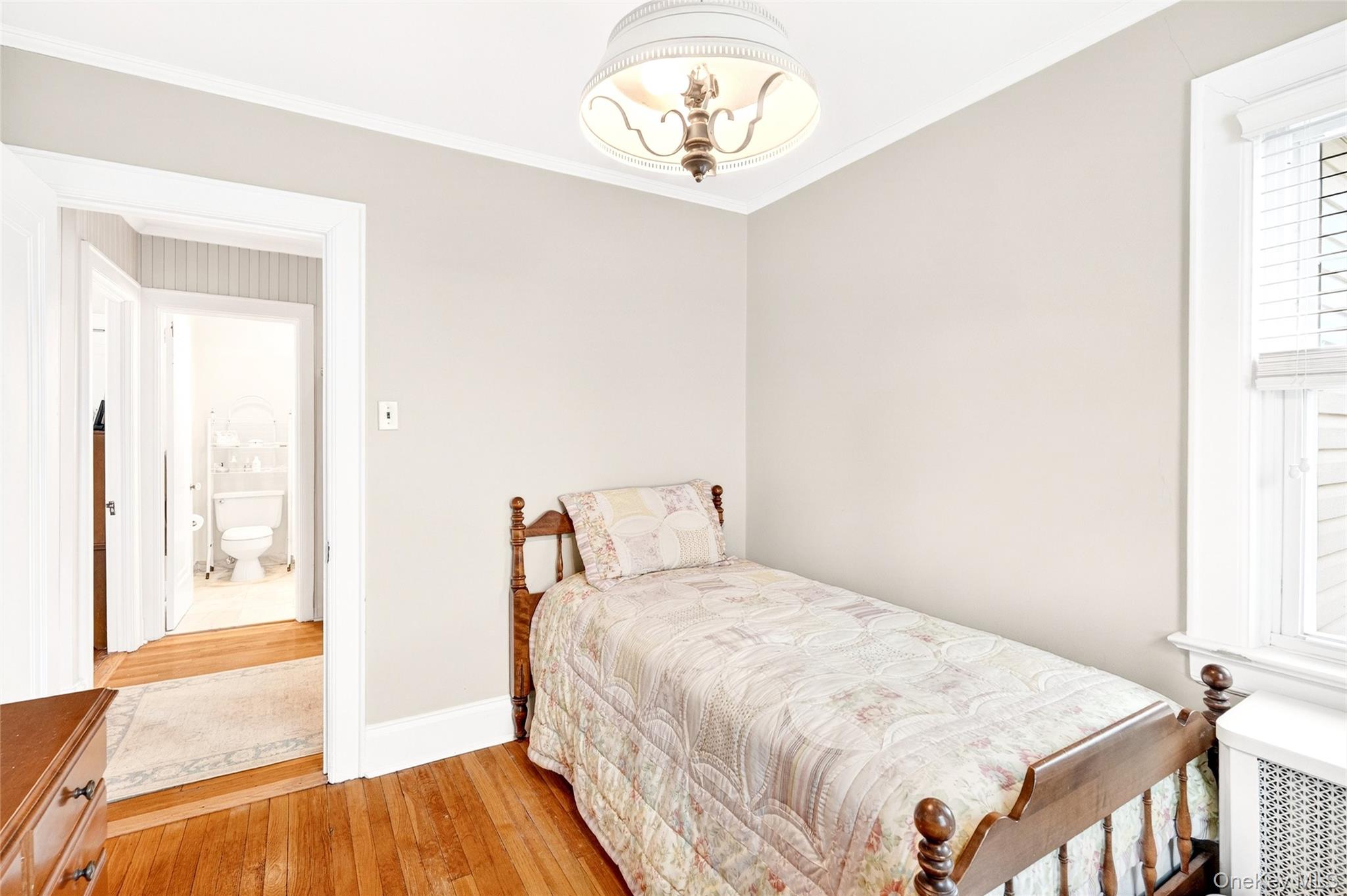 3334 Country Club Road Bronx, NY 10465 - Photo 36 of 49 Bedroom with radiator, light wood-type flooring, and crown molding