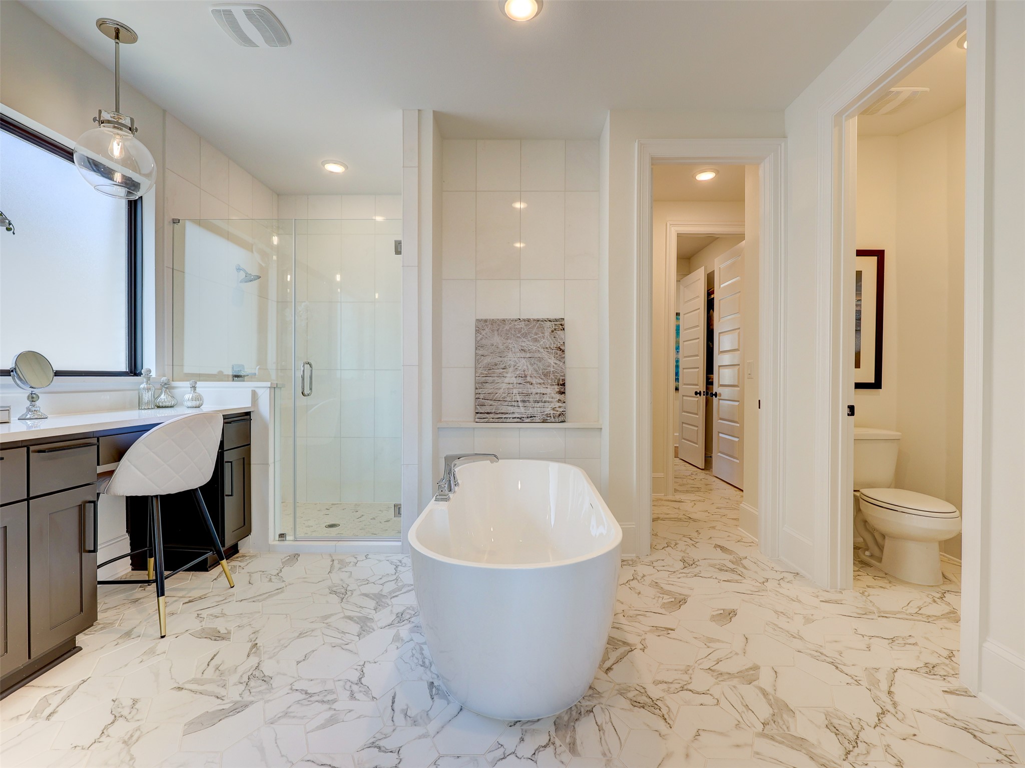 6220 Bower Well Road Austin, TX 78738 - Photo 12 of 28 Luxurious bathing retreat boasts a freestanding tub, separate shower, and elegant marble-look flooring.