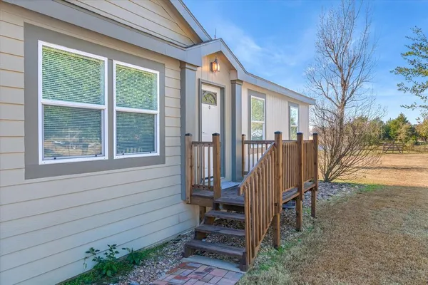 a large kitchen with kitchen island a stove a sink cabinets and wooden floor
