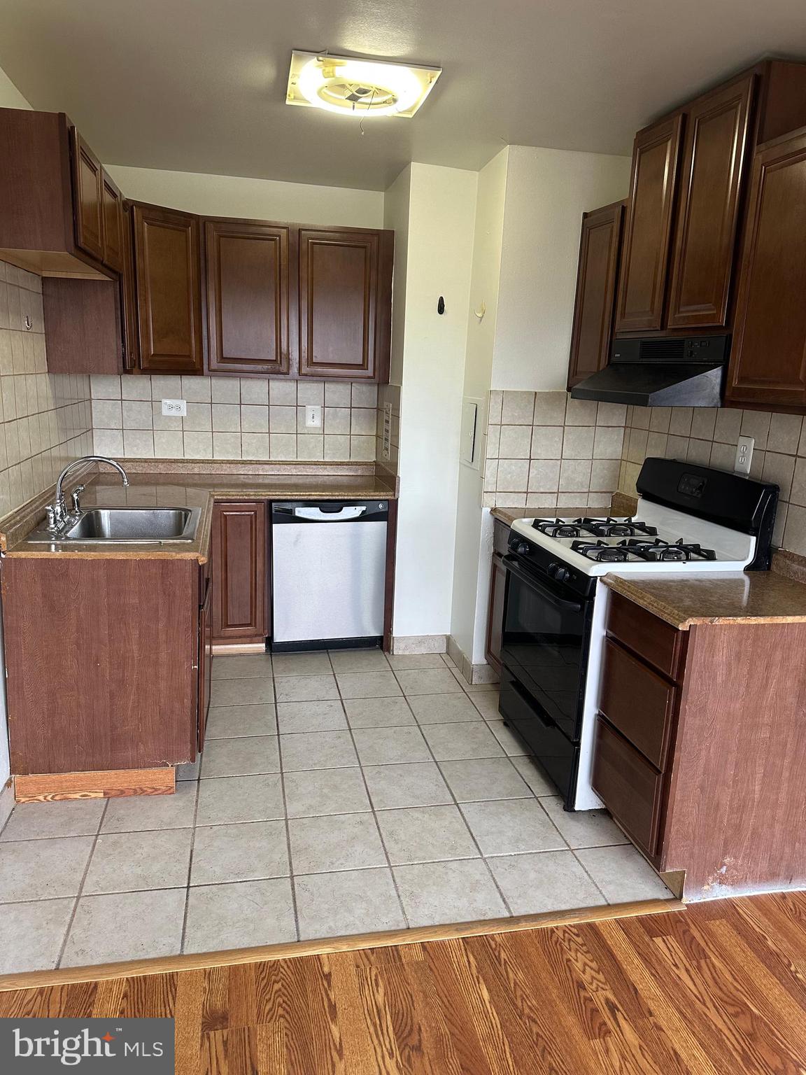 5801 Quantrell Avenue, Unit 407 Alexandria, VA 22312 - Photo 7 of 14 a kitchen with a sink a stove and a microwave