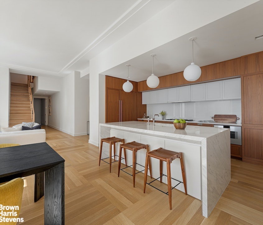 1289 Lexington Avenue, Unit 18C Manhattan, NY 10028 - Photo 4 of 20 a kitchen with a table chairs sink and cabinets