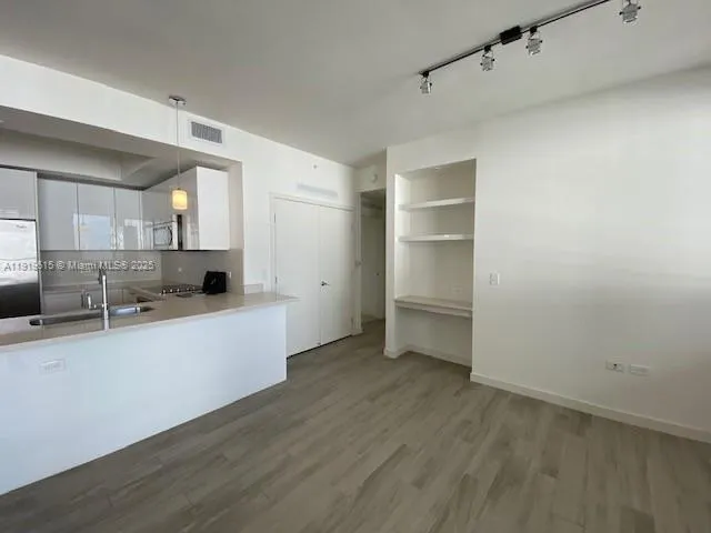 a large kitchen with a wooden floor and a large window