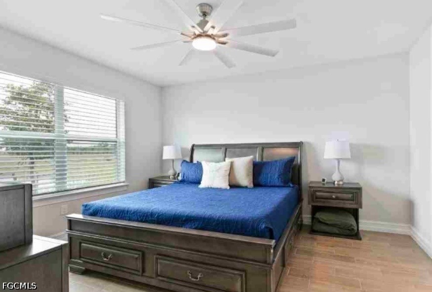 17799 Oleander Avenue Punta Gorda, FL 33982 - Photo 7 of 19 a bedroom with a bed and a ceiling fan with a large window
