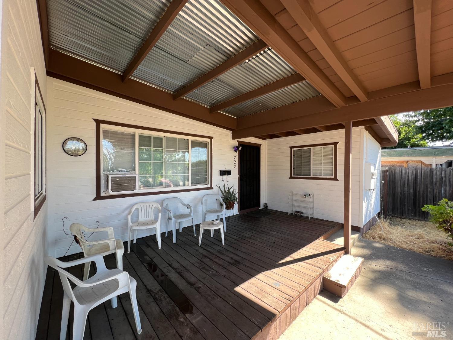 a view of a patio with table and chairs with wooden floor and fence
