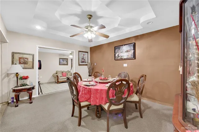a view of a dining room with furniture and chandelier fan