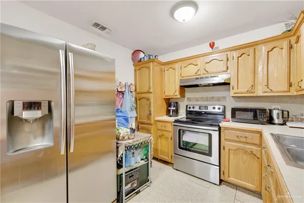 a kitchen with stainless steel appliances granite countertop a stove a refrigerator and a sink