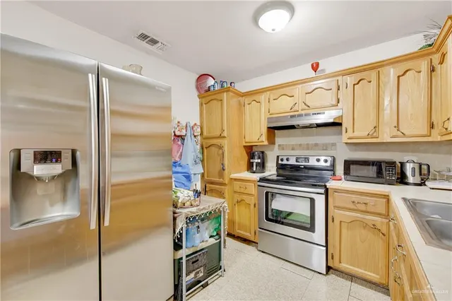 a kitchen with stainless steel appliances granite countertop a stove a refrigerator and a sink