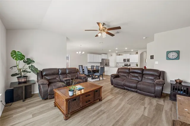 a living room with furniture ceiling fan and a wooden floor