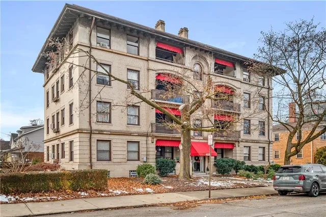 a front view of multi story residential apartment building with retail shops