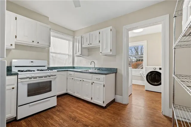 a kitchen with a stove oven and white cabinets