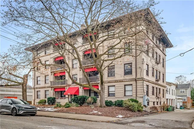 a street sign on a sidewalk next to a building
