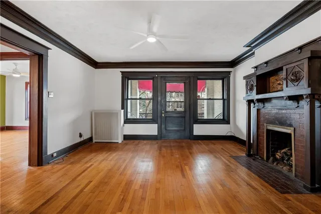 a view of a livingroom with wooden floor and a fireplace