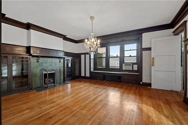 a view of a room with wooden floor fireplace and windows