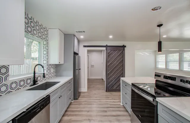 a kitchen with a sink stove and cabinets