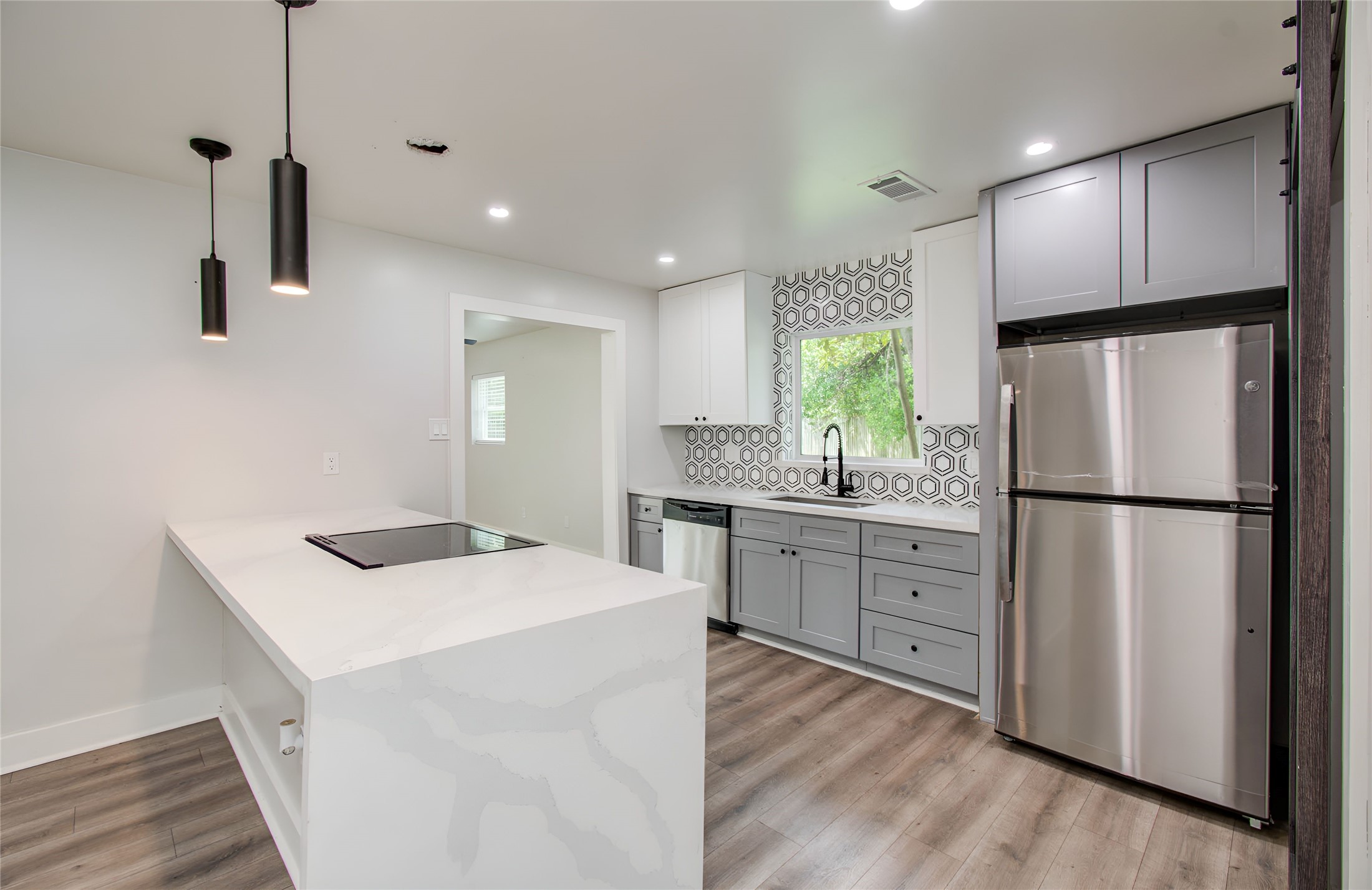 10415 Westray Street Houston, TX 77043 - Photo 17 of 45 a kitchen with granite countertop a refrigerator a sink dishwasher and a stove with wooden floor