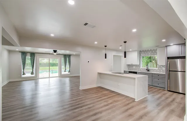 a large kitchen with cabinets wooden floor and a stainless steel appliances