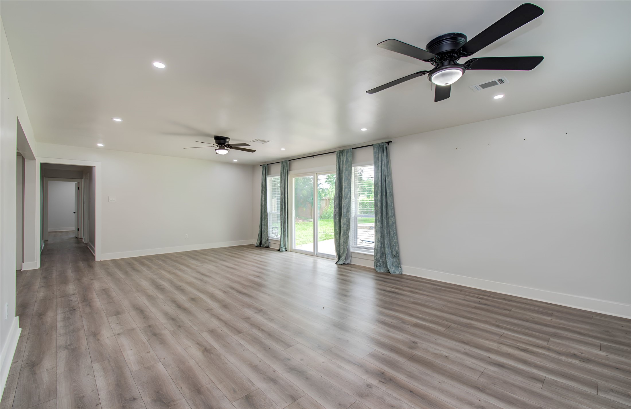 10415 Westray Street Houston, TX 77043 - Photo 26 of 45 an empty room with wooden floor and windows