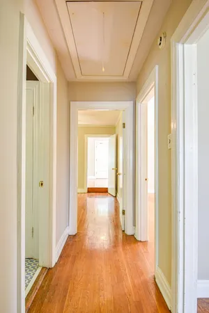 an empty room with wooden floor fireplace and windows