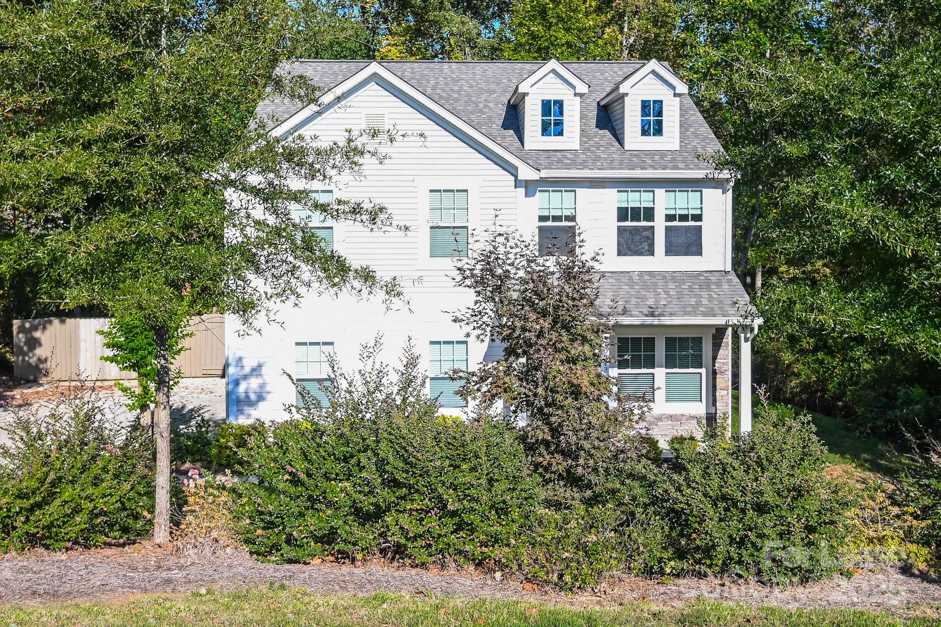 a front view of a house with a yard and trees