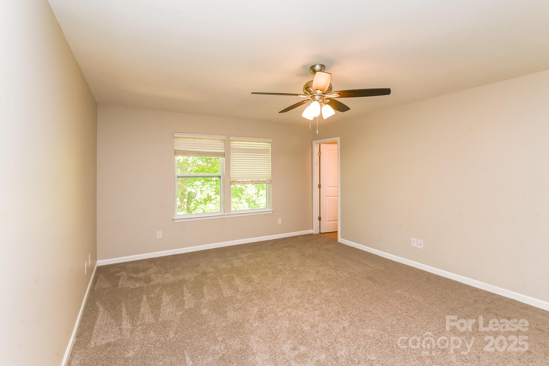 10813 Flintshire Road Mint Hill, NC 28227 - Photo 11 of 17 an empty room with a window and a fan