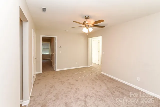 an empty room with a ceiling fan and a window