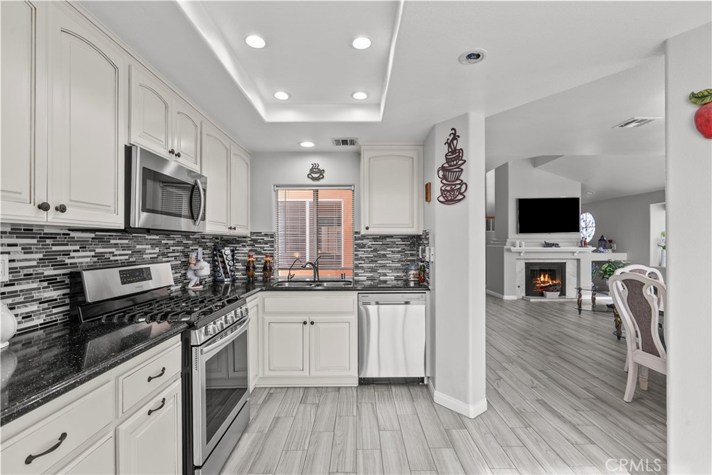 25726 Emerson Lane Stevenson Ranch, CA 91381 - Photo 14 of 45 a kitchen with stainless steel appliances a stove sink microwave and cabinets