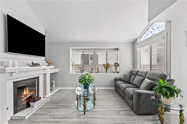 a living room with furniture a flat screen tv and a fireplace