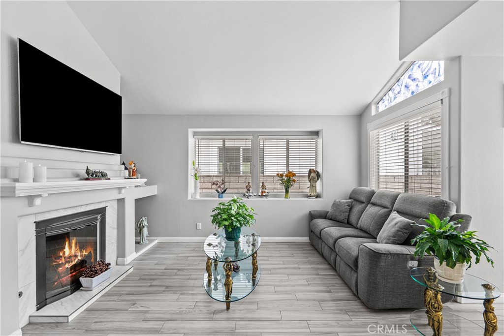25726 Emerson Lane Stevenson Ranch, CA 91381 - Photo 5 of 45 a living room with furniture a flat screen tv and a fireplace