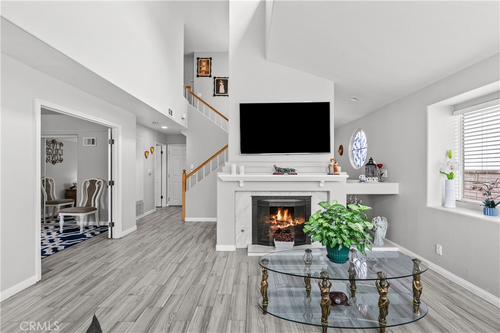 25726 Emerson Lane Stevenson Ranch, CA 91381 - Photo 7 of 45 a living room with furniture a fireplace and a flat screen tv