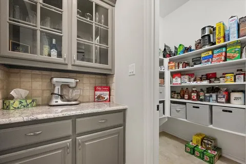 a cabinet with granite countertop lots of different kinds of food