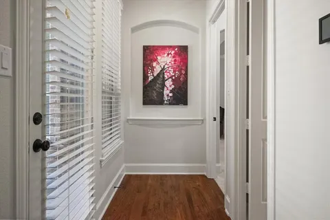 a view of a hallway with wooden floor and closet