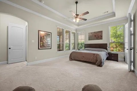 a bedroom with a large bed and a chandelier