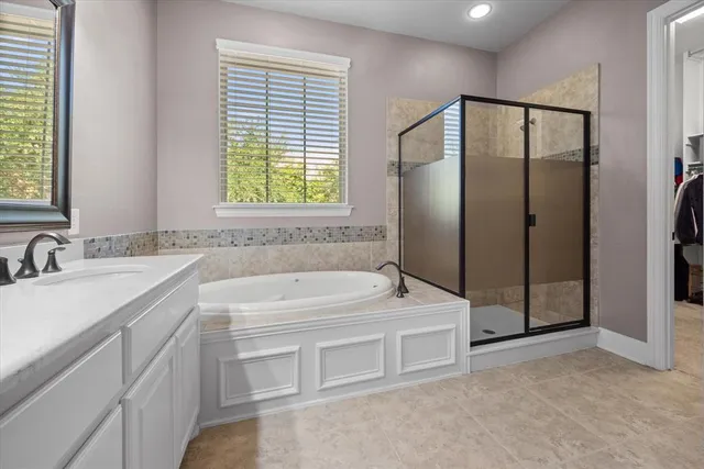 a bathroom with a tub a sink and a mirror