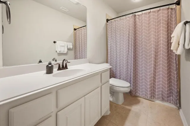 a bathroom with a sink a toilet and shower curtain