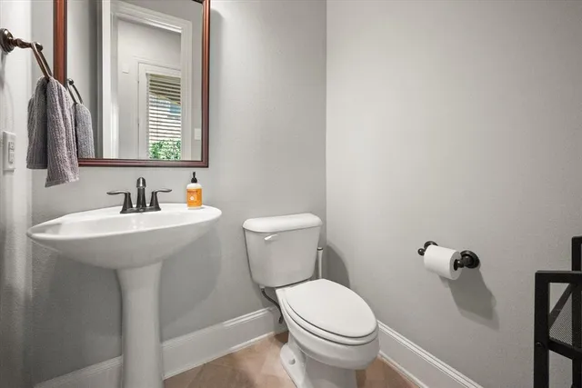 a bathroom with a sink a toilet and a mirror