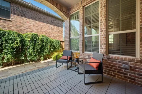 a balcony with wooden floor and outdoor seating