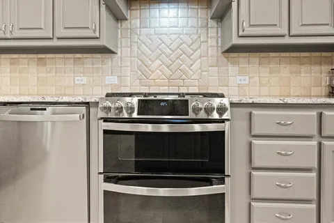 a stove top oven sitting inside of a kitchen and granite counter tops