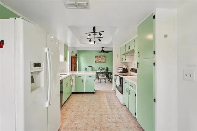 a view of kitchen with windows and refrigerator