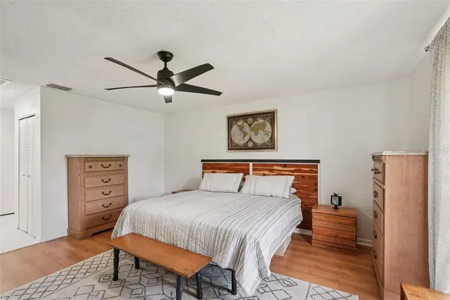 a bedroom with a bed a dresser and a chandelier