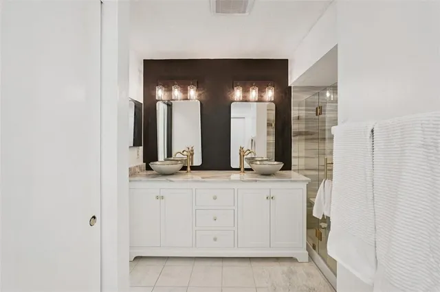 a bathroom with a double vanity and a mirror