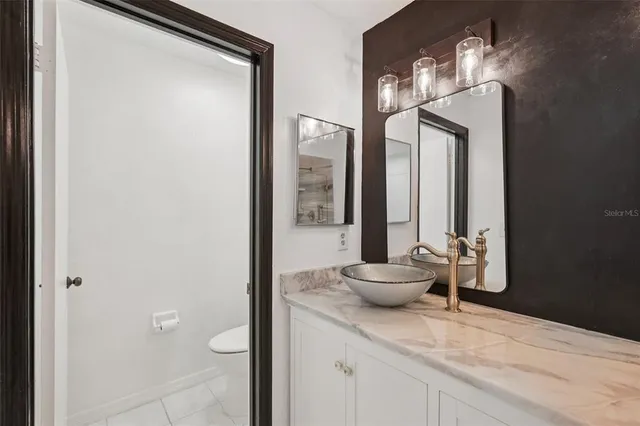 a bathroom with a granite countertop sink a toilet and a mirror