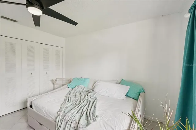a bedroom with a bed and a ceiling fan