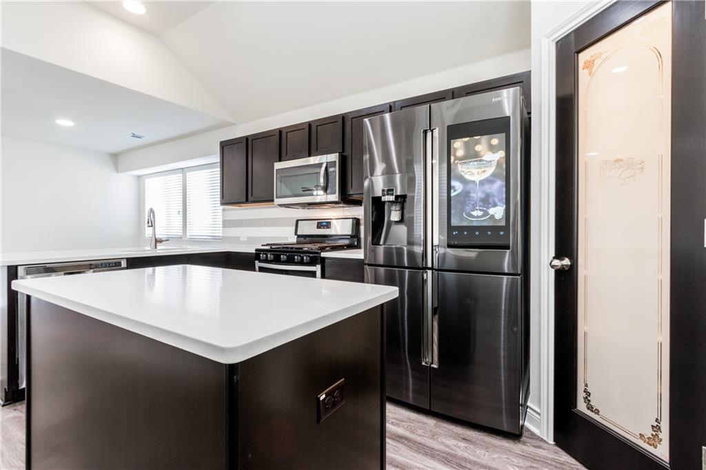 2104 Pindos Pony Way Georgetown, TX 78626 - Photo 10 of 30 White countertops and dark wood cabinetry create a striking contrast in this contemporary kitchen.