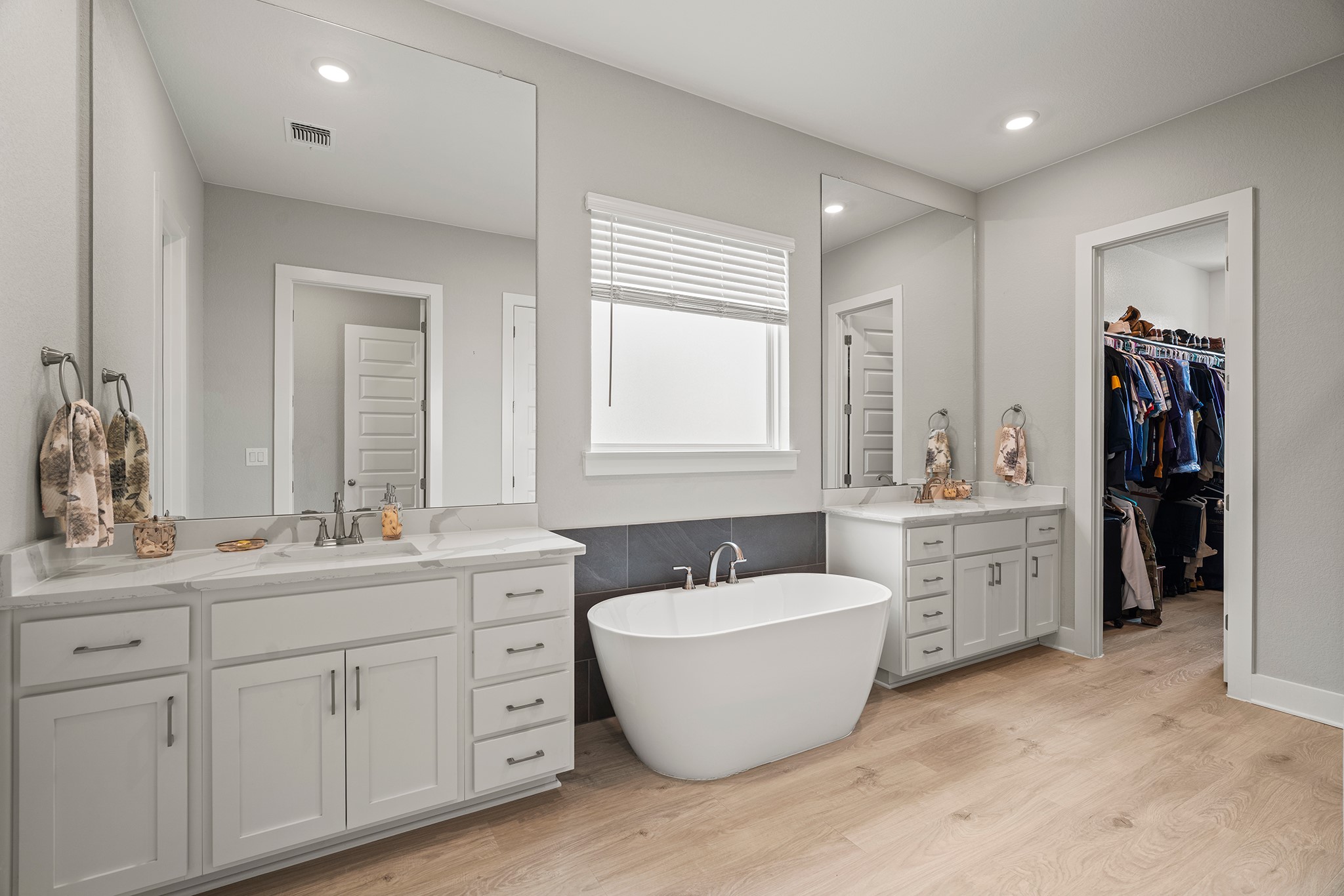 2112 Tobiano Trace Georgetown, TX 78633 - Photo 17 of 40 Bathroom featuring a freestanding tub, two vanities, light wood finished floors, a walk in closet, and recessed lighting