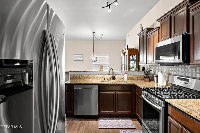 a kitchen with stainless steel appliances granite countertop a stove top oven a sink and dishwasher