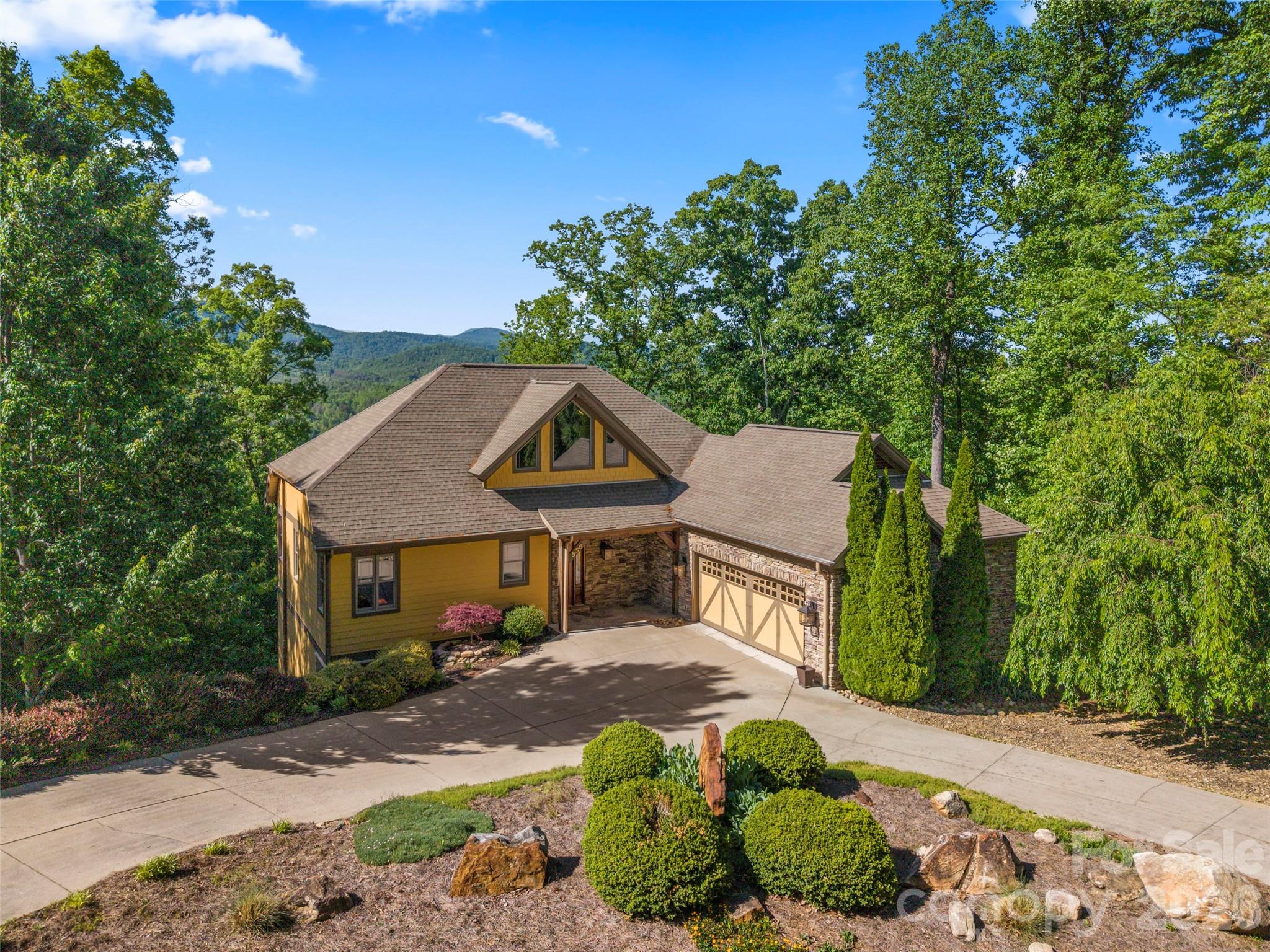 556 High Pines Loop Lake Lure, NC 28746 - Photo 1 of 46 a front view of a house with a garden