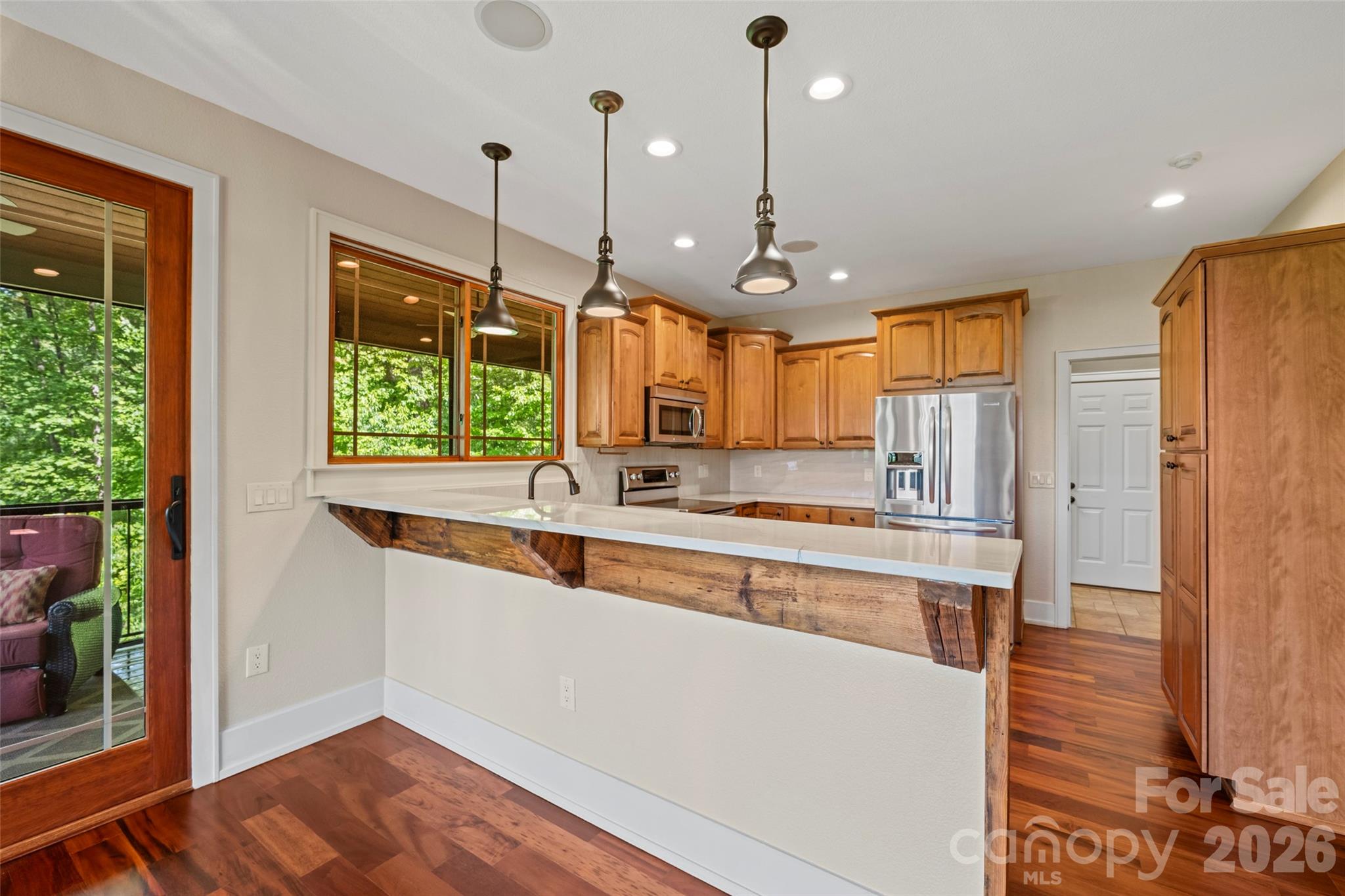 556 High Pines Loop Lake Lure, NC 28746 - Photo 13 of 46 a large kitchen with stainless steel appliances granite countertop a stove a refrigerator a oven and a wooden cabinets