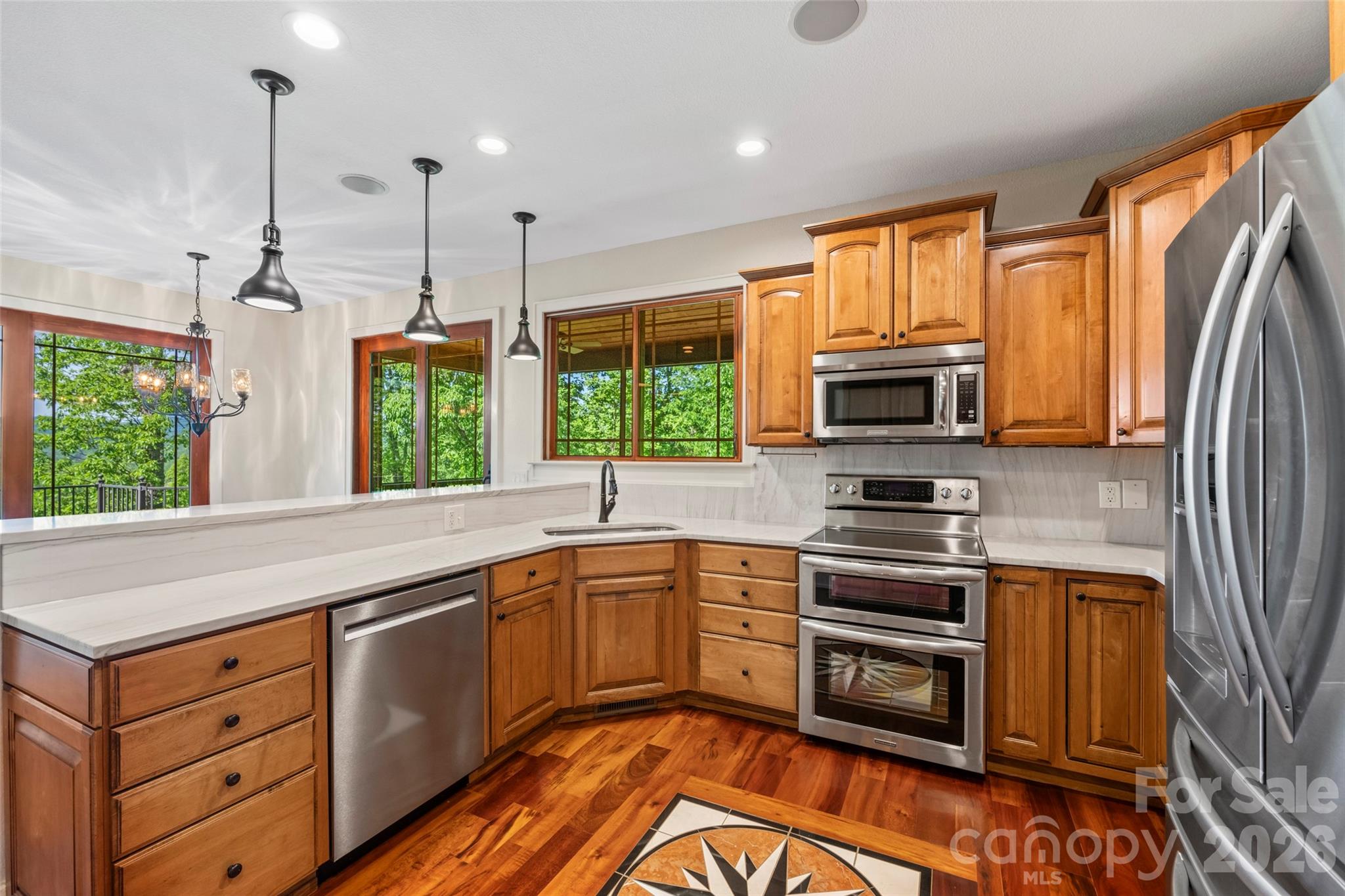 556 High Pines Loop Lake Lure, NC 28746 - Photo 14 of 46 a kitchen with stainless steel appliances granite countertop a stove a sink and a refrigerator with wooden floor