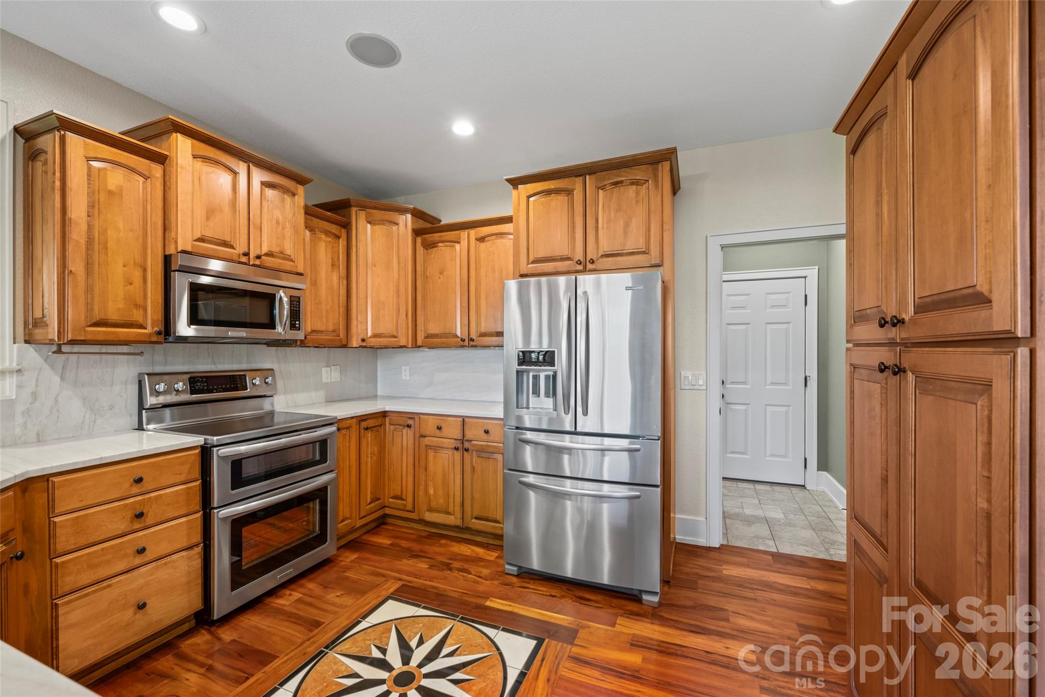 556 High Pines Loop Lake Lure, NC 28746 - Photo 15 of 46 a kitchen with stainless steel appliances granite countertop a refrigerator microwave and wooden floor