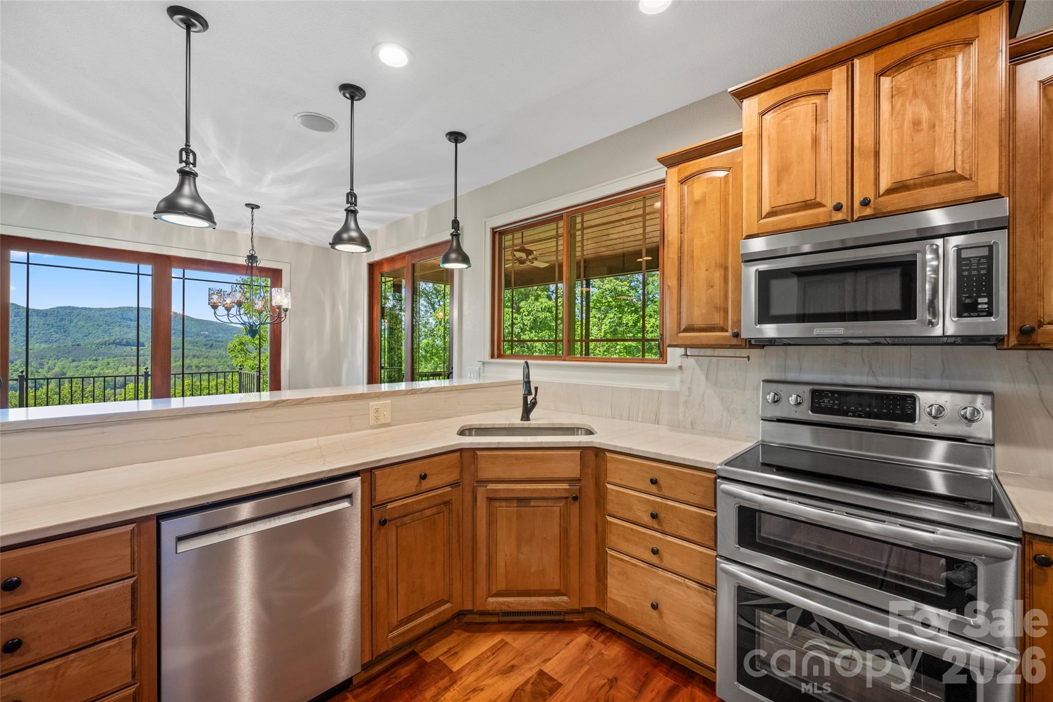 556 High Pines Loop Lake Lure, NC 28746 - Photo 16 of 46 a kitchen with stainless steel appliances granite countertop a stove sink and microwave